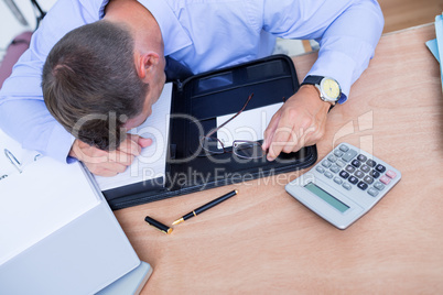 Exhausted businessman sleeping on the desk