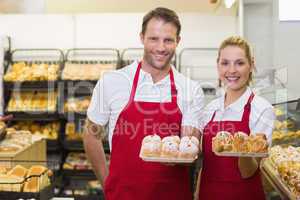 Portrait of smiling bakers having a pastry