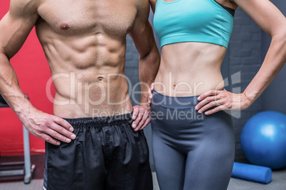 Muscular couple with hands on the hips