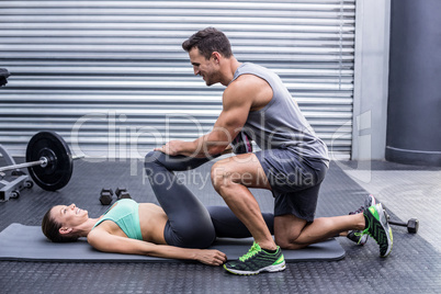 Muscular couple doing a leg stretching