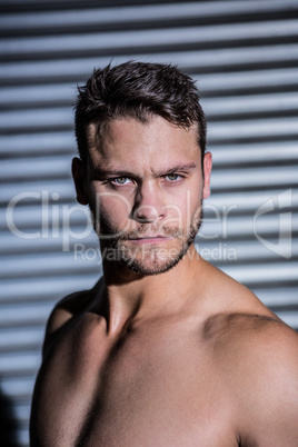 Portrait of serious muscular man looking at camera