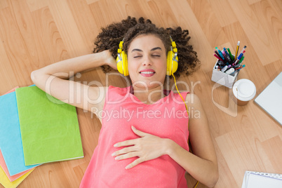 Young creative businesswoman enjoying music