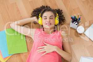 Young creative businesswoman enjoying music