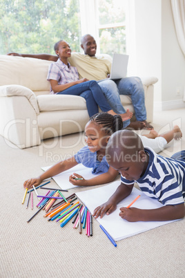 Happy siblings on the floor drawing