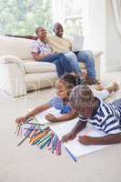 Happy siblings on the floor drawing