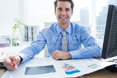 Happy businessman writing at his desk