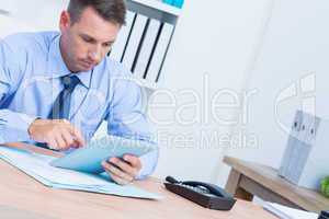 Serious businessman using digital tablet