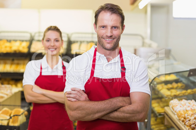 Portrait of smiling two bakers with arms crossed