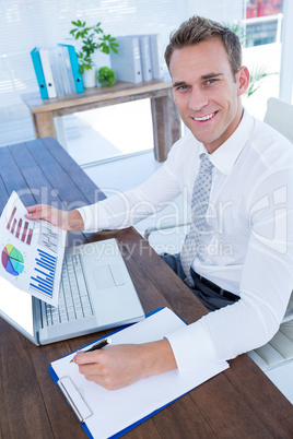 Smiling businessman working with flow charts