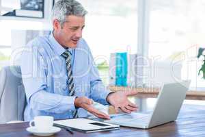 Confused businessman looking at laptop computer