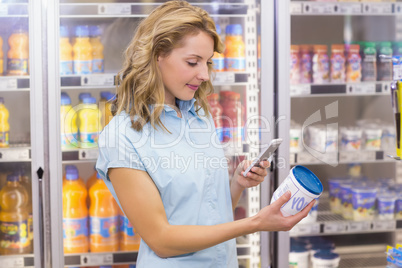 Smiling woman taking a picture of a cream cheese