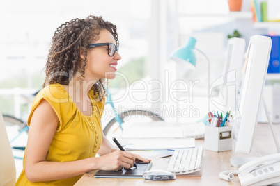 Creative young businesswoman drawing on graphic tablet