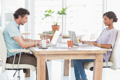 Casual business partners working on laptop