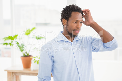 Young thinking businessman scratching his head