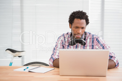 Young businessman looks confused at his laptop