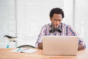 Young businessman looks confused at his laptop