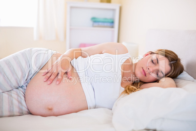 Pregnant woman sleeping on bed