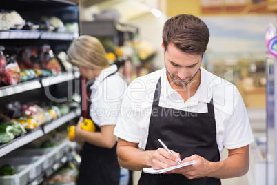 A serious staff man writing on notepad