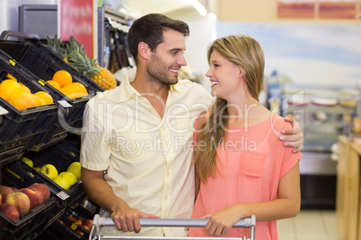 Smiling bright couple buying food products