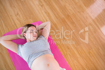 Pregnant woman relaxing on exercise mat
