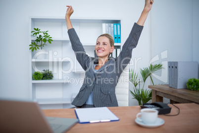 Pretty blonde businesswoman gesturing victory