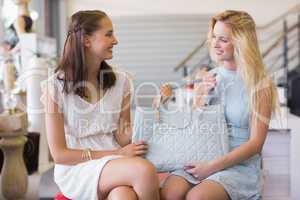 Two happy women holding a handbag