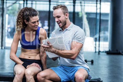 Muscular woman watching her results on clipboard