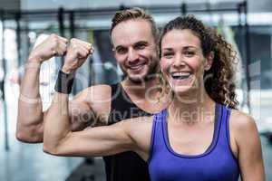 Smiling muscular couple flexing biceps