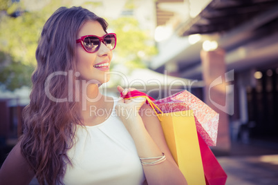 Smiling woman with shopping bags wearing sunglasses