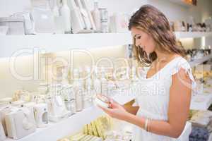 Smiling woman testing moisturizer