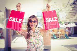 Portrait of euphoric woman holding two sale shopping bags