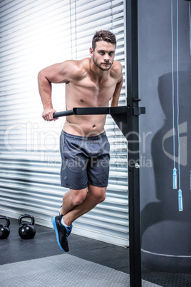 Portrait of muscular man exercising with bars