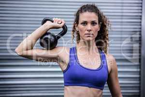 Portrait of muscular woman exercising with kettlebell