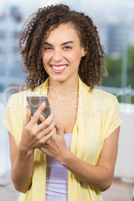 Smiling businesswoman holding her phone