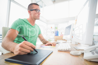 Young creative businessman drawing on graphic tablet