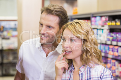 Smiling casual couple looking at shelf