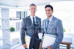 Happy businessman looking at camera and holding files