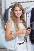 A pretty smiling blonde woman looking at her smartphone