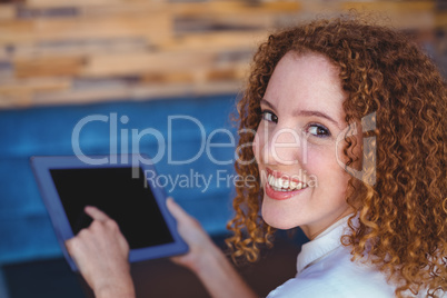 Pretty girl using a small tablet at table