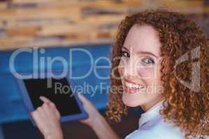 Pretty girl using a small tablet at table