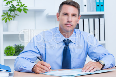 Portrait of serious businessman writing