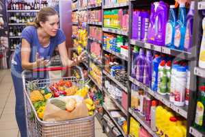 Surprised woman looking at product on shelf