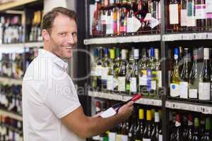 Portrait of a smiling handsome having a wine bottle in her hands