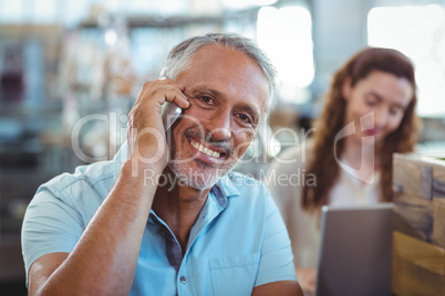 Happy man having phone call and smiling at camera