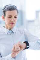 A businesswoman using her smartwatch
