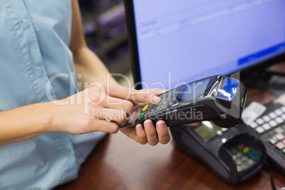 Woman at cash register paying with credit card