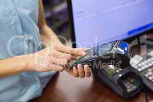 Woman at cash register paying with credit card