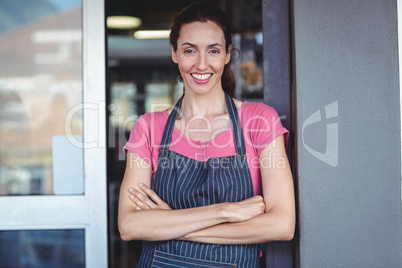 Smiling worker looking at camera with arm crossed