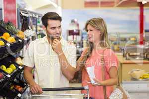 Smiling bright couple buying food products