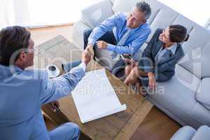 Business people shake hands on couch